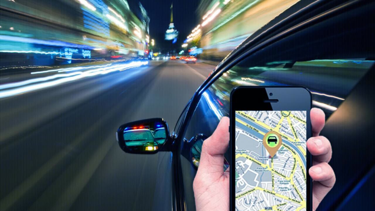 Mão segurando celular com mapa mostrando a localização do veículo